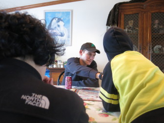 Phillip Carstens plays a board game with his family.