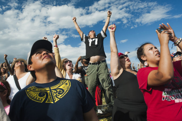 People raise their fists in the air in solidarity as a group of canoes arrives in a protest camp that sprang up to demonstrate against the Energy Transfer Partners’ Dakota Access oil pipeline near the Standing Rock Sioux Reservation in Cannon Ball, North Dakota. The canoe flotilla had representatives of tribes from the across the Pacific Northwest and navigated the Missouri River from Bismarck to Cannon Ball to show their support. 